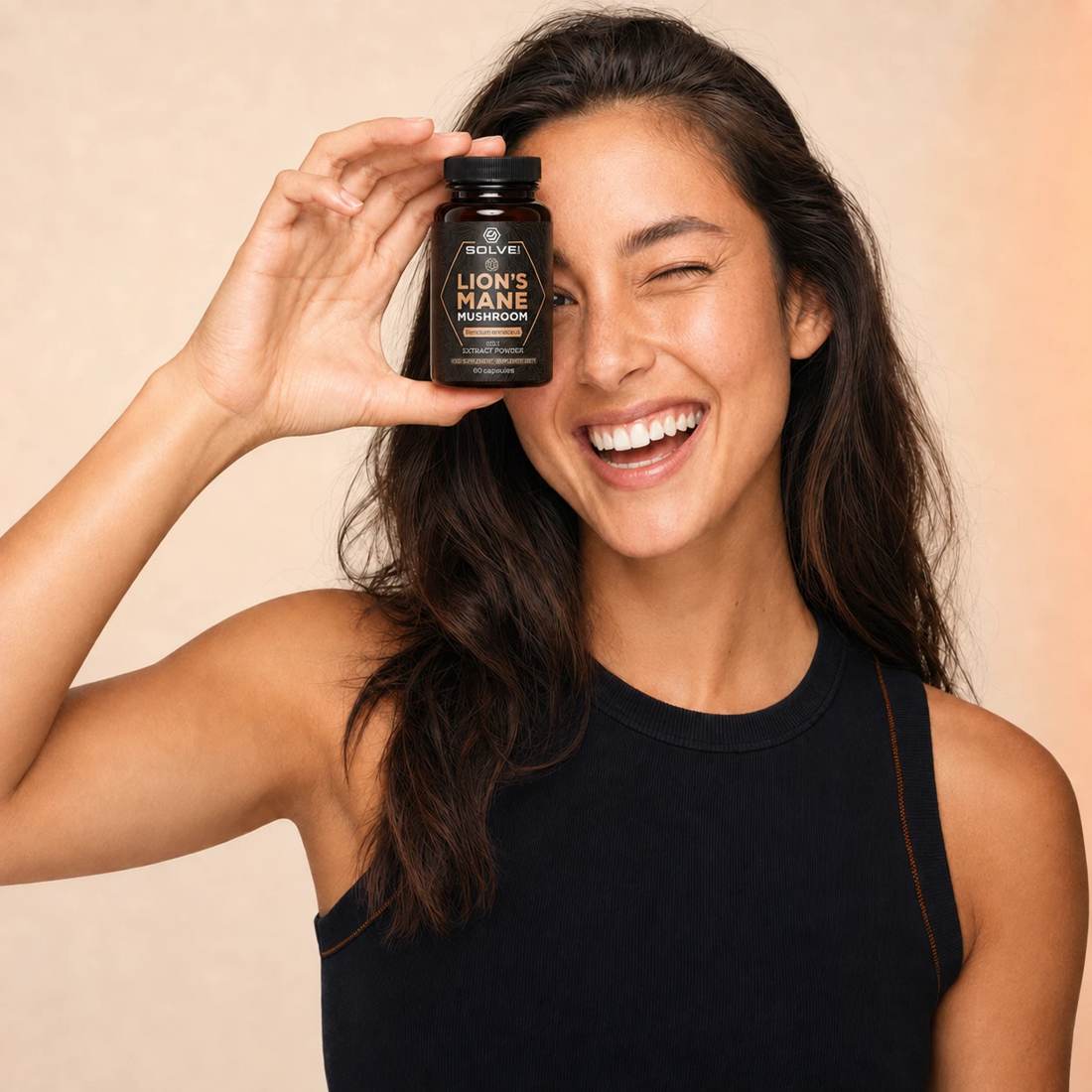 Customer holding a jar of Solve Labs Lion&rsquo;s Mane over one eye, smiling